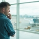 Mand med flyskræk står i lufthavnen og kigger ud på flyvemaskiner